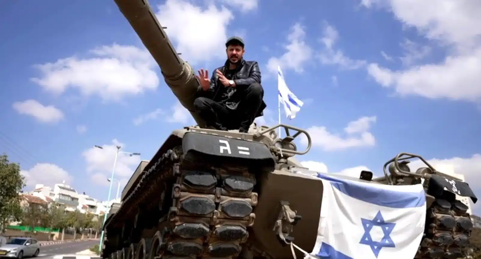 מילואימניק יושב על טנק עטור דגלי ישראל