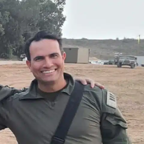 Shai of the Miluimnikim community, smiling in uniform