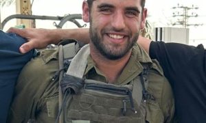 לוחם צעיר מחייך בציוד קרבי