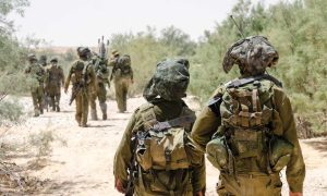 לוחמי מילואים צועדים בשטח עם ציוד מלא